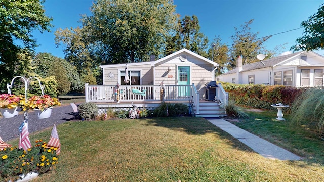 view of front of property featuring a wooden deck and a front lawn