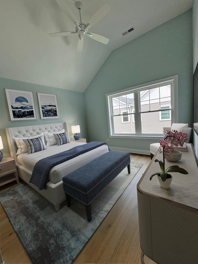 bedroom featuring lofted ceiling, visible vents, multiple windows, and wood finished floors