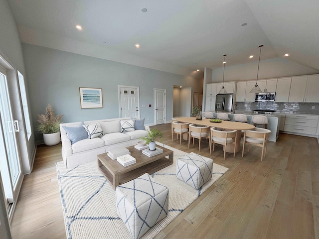 living area featuring vaulted ceiling and light wood-type flooring