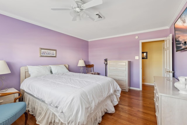 bedroom with hardwood / wood-style floors, crown molding, and ceiling fan