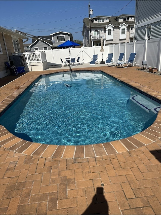 view of swimming pool featuring a patio area and central air condition unit