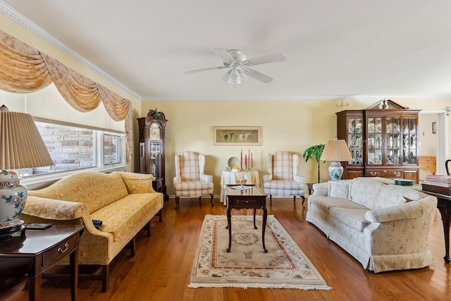 living room with dark hardwood / wood-style flooring, ornamental molding, and ceiling fan