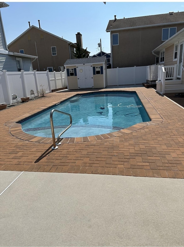 view of swimming pool with a patio area and a shed