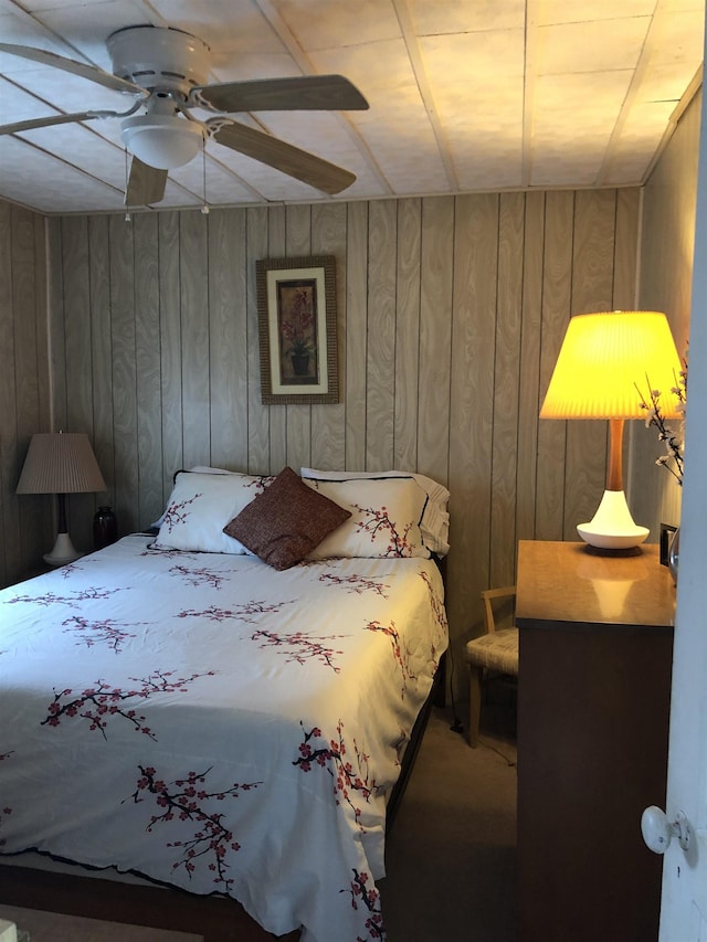 unfurnished bedroom with ceiling fan and wooden walls