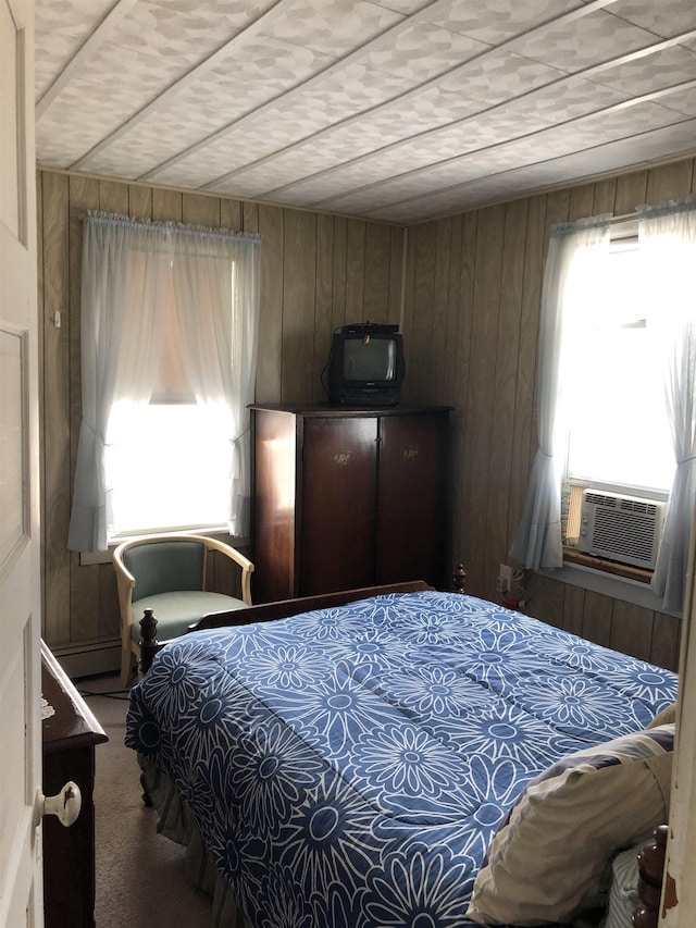 carpeted bedroom featuring wood walls and cooling unit