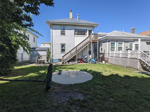 back of house featuring a yard, a patio, and a wooden deck