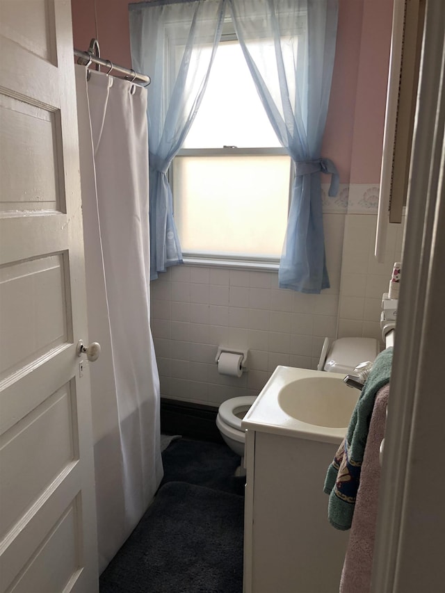 bathroom with plenty of natural light, vanity, tile walls, and toilet