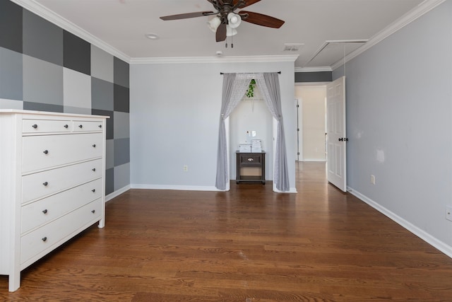 unfurnished bedroom featuring baseboards, dark wood-type flooring, attic access, and crown molding