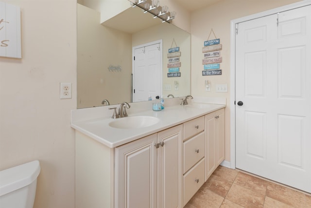 bathroom with double vanity, a sink, and toilet