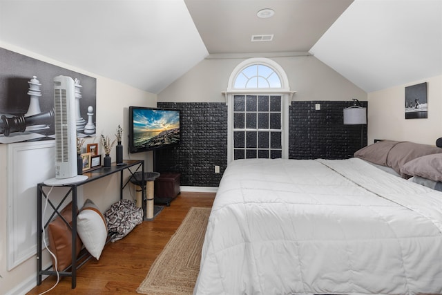 bedroom featuring vaulted ceiling, wood finished floors, visible vents, and baseboards