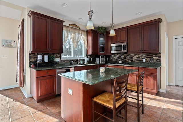 kitchen featuring a breakfast bar, decorative backsplash, stainless steel appliances, and a sink