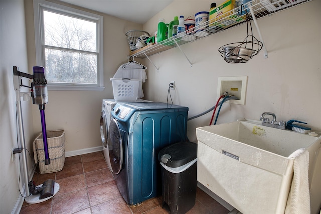 washroom featuring laundry area, baseboards, washer and clothes dryer, tile patterned floors, and a sink