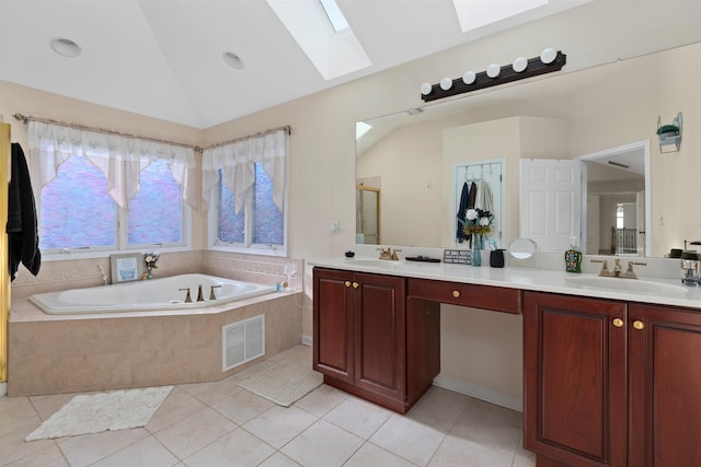 bathroom with double vanity, vaulted ceiling with skylight, visible vents, a garden tub, and a sink