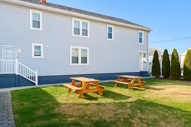 rear view of property with a lawn