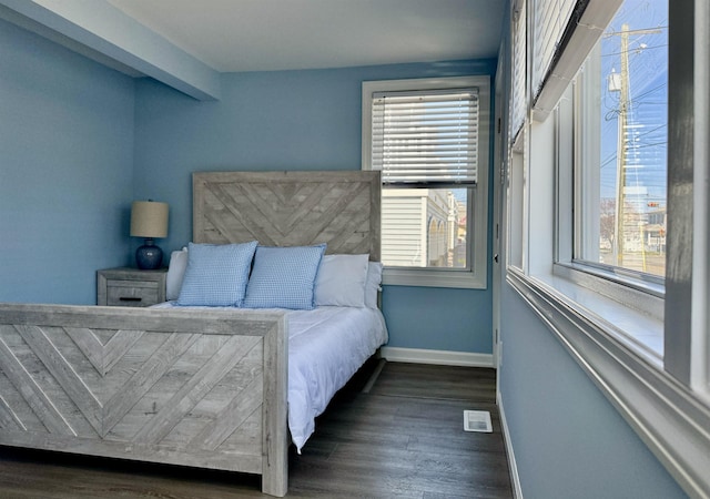 bedroom with dark wood-style flooring, baseboards, and visible vents