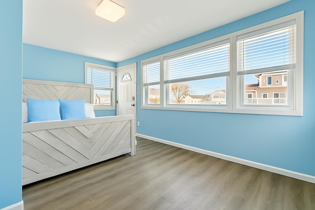 bedroom with baseboards and wood finished floors