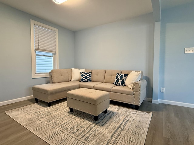 living room featuring dark wood-type flooring and baseboards