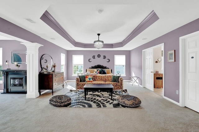 carpeted bedroom with ceiling fan with notable chandelier, decorative columns, a raised ceiling, and crown molding