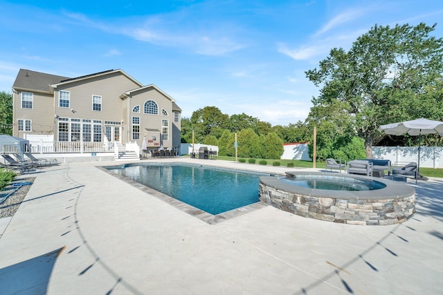 view of swimming pool with a patio area and an in ground hot tub