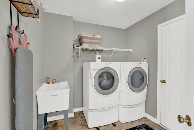 clothes washing area with independent washer and dryer and sink