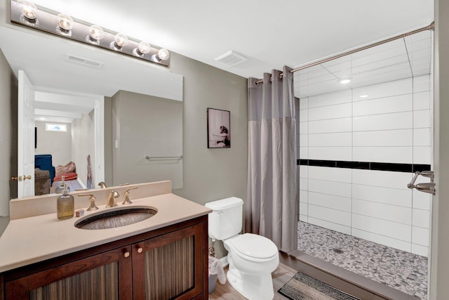 bathroom featuring vanity, curtained shower, and toilet