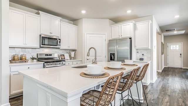 942 Carol Ave, Lower Township, NJ 08204 - kitchen with stainless steel appliances, a sink, decorative backsplash, an island with sink, and light countertops