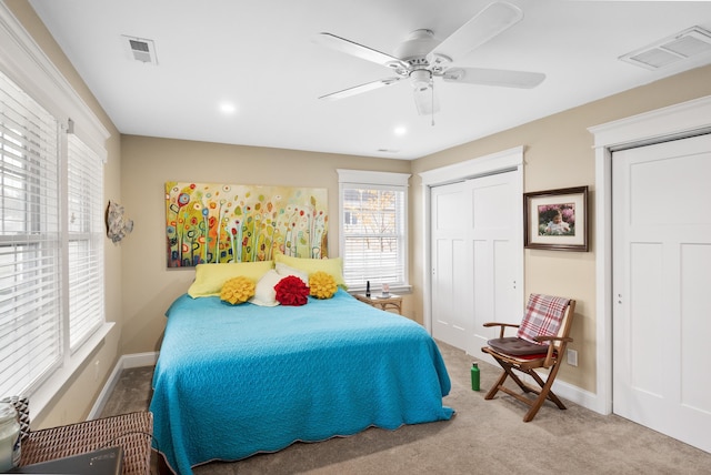 bedroom featuring a closet, light colored carpet, and ceiling fan