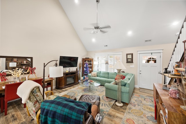 living room with ceiling fan, high vaulted ceiling, and hardwood / wood-style floors