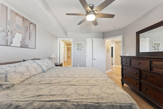 bedroom with light wood-type flooring, ensuite bathroom, and ceiling fan