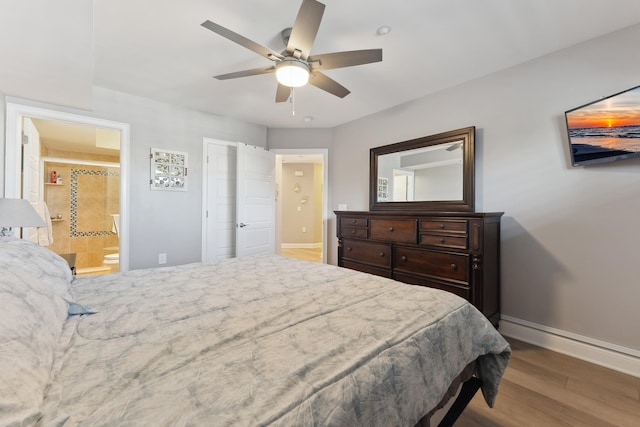 bedroom featuring hardwood / wood-style floors, ceiling fan, and ensuite bath