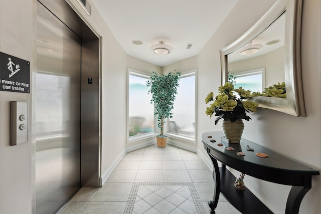 hallway with light tile patterned flooring and elevator