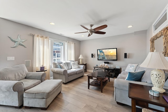 living room featuring ceiling fan and light hardwood / wood-style flooring