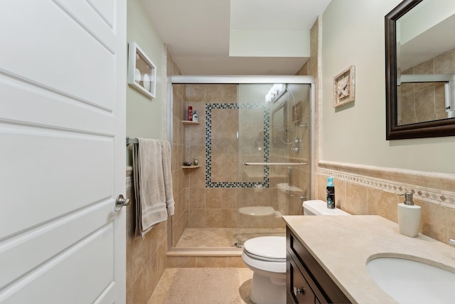 bathroom featuring an enclosed shower, vanity, tile walls, tile patterned flooring, and toilet