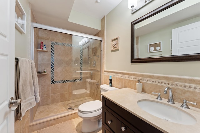 bathroom with vanity, an enclosed shower, tile walls, and toilet