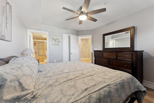 bedroom featuring hardwood / wood-style flooring, ceiling fan, and connected bathroom