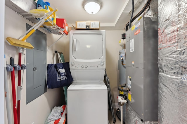 clothes washing area with stacked washer / drying machine, electric panel, and heating unit