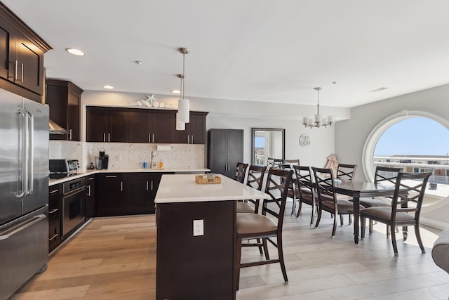 kitchen with pendant lighting, a center island, stainless steel appliances, and plenty of natural light