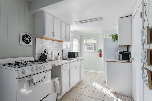 kitchen with visible vents, white cabinets, a sink, white gas range, and backsplash