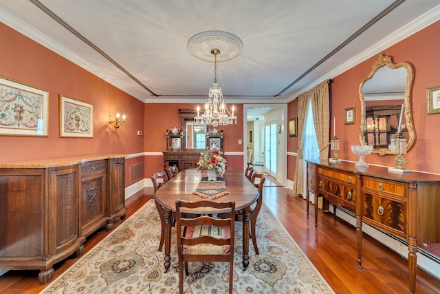 645 Hughes St, Cape May, NJ 08204 - dining area with a chandelier, wood finished floors, crown molding, baseboard heating, and a wainscoted wall