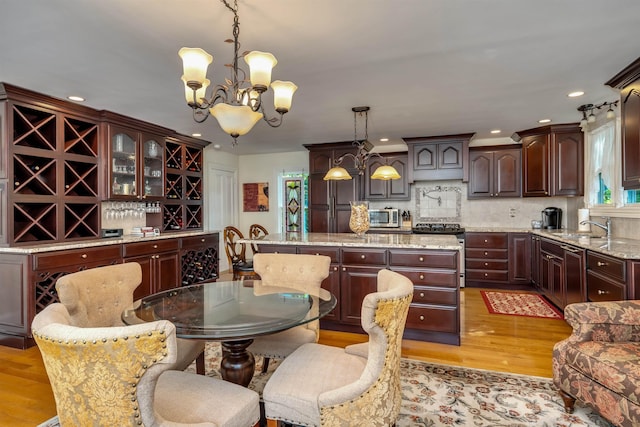 645 Hughes St, Cape May, NJ 08204 - kitchen featuring a kitchen island, appliances with stainless steel finishes, light wood-style floors, a chandelier, and recessed lighting