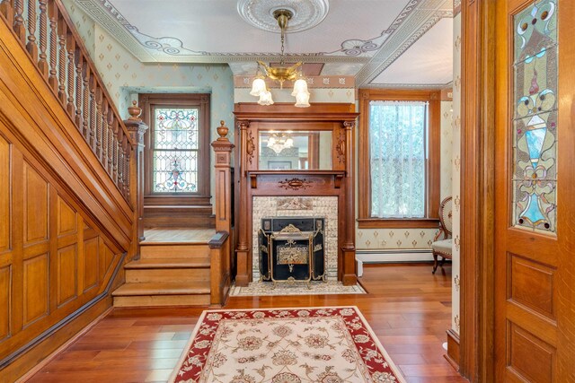 645 Hughes St, Cape May, NJ 08204 - foyer entrance featuring wallpapered walls, stairs, hardwood / wood-style flooring, a baseboard radiator, and a chandelier