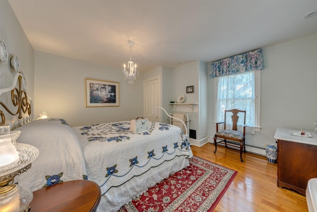 645 Hughes St, Cape May, NJ 08204 - bedroom featuring baseboard heating, light wood-type flooring, and a chandelier