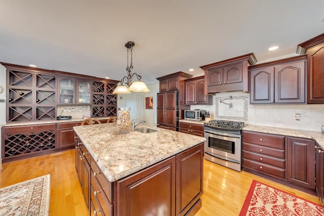 645 Hughes St, Cape May, NJ 08204 - kitchen featuring stainless steel appliances, light wood-style flooring, tasteful backsplash, an island with sink, and recessed lighting
