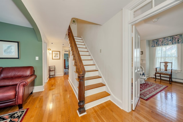 645 Hughes St, Cape May, NJ 08204 - staircase with hardwood / wood-style flooring, arched walkways, and baseboard heating