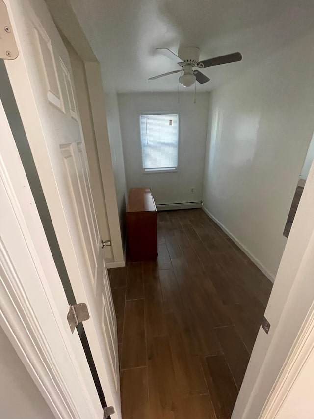 corridor with dark wood-type flooring and a baseboard radiator