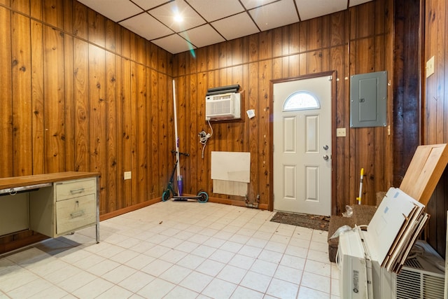foyer featuring wooden walls, a wall mounted air conditioner, electric panel, and a paneled ceiling