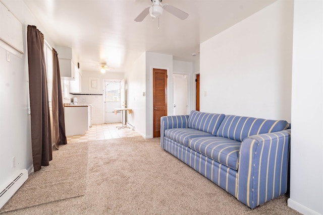 living room featuring a baseboard heating unit, ceiling fan, baseboards, and light colored carpet