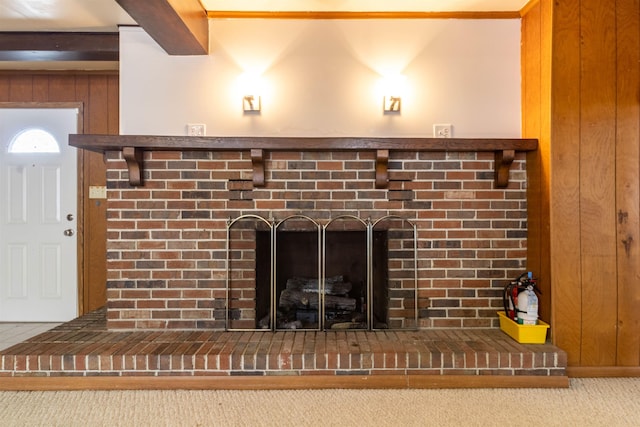details with a fire extinguisher, a brick fireplace, wooden walls, and carpet