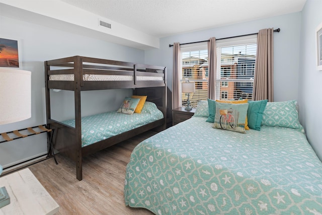 bedroom with wood finished floors and visible vents