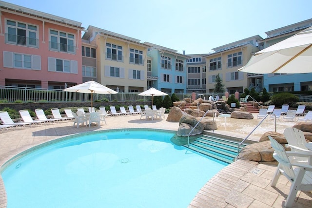 pool with a patio area and fence